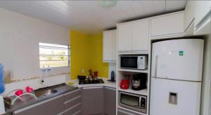 eine Küche mit weißen Schränken und einem weißen Kühlschrank in der Unterkunft Casa em floripa in Florianópolis