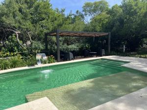 a swimming pool with a gazebo in a yard at Cabañas Apart Margaridas in Merlo