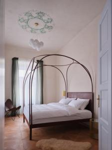 donebe hotel & wellness Kutná Hora في كوتنا هورا: غرفة نوم بسرير كبير بها مظلة معدنية