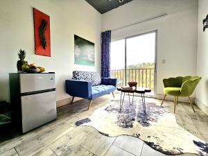 Jardin De Poas Hotel & Nature Resort في Poás: غرفة معيشة بها أريكة وكرسي وطاولة