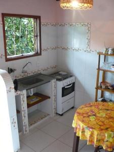 una cucina con un lavandino, un fornello e una finestra di Chalé Borboletas Centro Pipa RN a Pipa