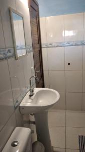 un bagno bianco con lavandino e doccia di Chalé Borboletas Centro Pipa RN a Pipa