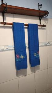 due asciugamani blu appesi su un attaccapanni in un bagno di Chalé Borboletas Centro Pipa RN a Pipa