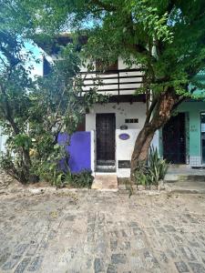 una casa con un albero davanti di Chalé Borboletas Centro Pipa RN a Pipa