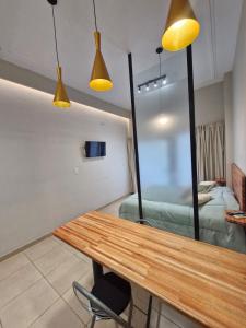 Monoambiente de diseño في كورينتس: غرفة مع طاولة خشبية وغرفة نوم