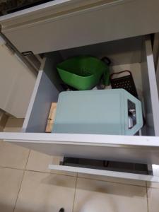 a shelf in a kitchen with a green bowl at Monoambiente de diseño in Corrientes