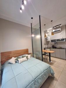 Monoambiente de diseño في كورينتس: غرفة نوم بسرير ازرق كبير ومطبخ