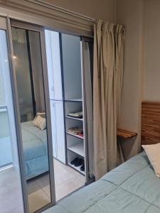 Monoambiente de diseño في كورينتس: غرفة نوم بسرير وخزانة زجاجية +19 صورة