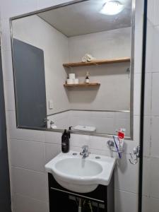 Monoambiente de diseño في كورينتس: حمام مزود بحوض ومِرآة