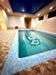 a swimming pool with a flower painted on it at Cosmos Hotel in Yakkasaray