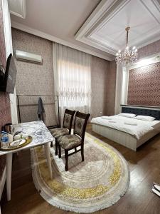 a bedroom with a bed and a table and chairs at Cosmos Hotel in Yakkasaray