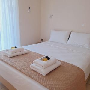 a bedroom with a bed with towels on it at Olivo Nydri in Nydri