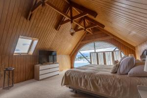Un dormitorio con una cama grande y un televisor. en Lady Florence Dixie, en Puerto Natales