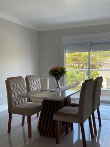 Dolce Vita في بورتو بيلو: غرفة طعام بها طاولة وكراسي ونافذة