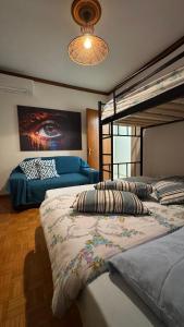 een slaapkamer met twee stapelbedden en een bank bij Carolos‘ house in Kavala +28 foto's