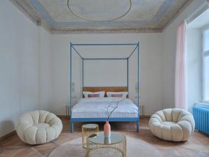 donebe hotel & wellness Kutná Hora في كوتنا هورا: غرفة نوم بسرير مع كرسيين وطاولة