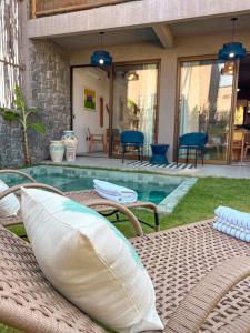 une table de patio avec des coussins à côté d'une piscine dans l'établissement Zami 03 & 04, à Porto de Pedras
