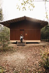 a woman is standing in front of a building at Micro-cabine, Méandre, La Tuque in La Tuque +9 photos