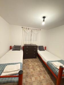 two twin beds in a room with a window at Cabaña in Vaqueros