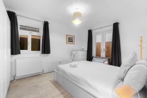 a bedroom with a white bed and a window at 2 Bedroom house,BrownhillRd SE6 in London