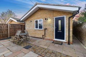 a small brick house with a black door at 2 Bedroom house,BrownhillRd SE6 in London