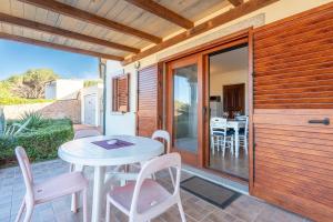 d'une terrasse avec une table et des chaises blanches. dans l'établissement GF Apartments Li Seddi, à Badesi