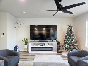 a living room with a christmas tree and a flat screen tv at Boise Cozy House in Boise