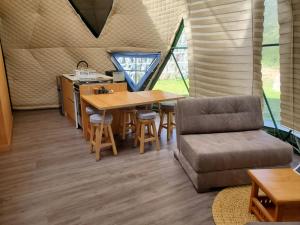 Permasalud Glamping : غرفة معيشة بها طاولة وأريكة