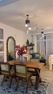 een woonkamer met een houten tafel en stoelen bij Malindi Modern 2BR Apartment in Malindi