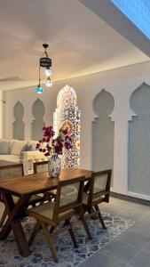 een eettafel met een vaas met bloemen erop bij Malindi Modern 2BR Apartment in Malindi