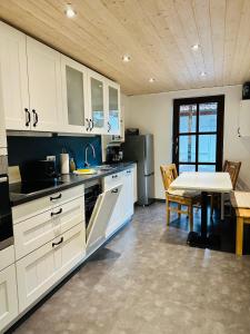 a kitchen with white cabinets and a table in it at Apartment BERGfamilie - gemütlich ausgestattet, ruhig und familienfreundlich in Schliersee