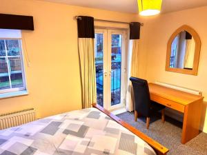 Sorrell Gardens Guest House في نيوكاسل أندر ليم: غرفة نوم مع مكتب وسرير بجانب نافذة