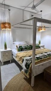 een slaapkamer met een hemelbed en een tapijt bij Malindi Modern 2BR Apartment in Malindi