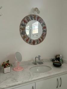 un bancone del bagno con lavandino e specchio di Espaço mel a Búzios Altre 43 foto