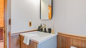 a bathroom with a white sink and a mirror at 5BDR Hot Tub Deck Firepit Mins to Village Lake The Hilltop by AvantStay in North Shore +42 photos