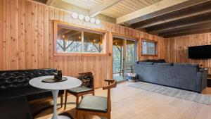 a living room with a couch and a table at 5BDR Hot Tub Deck Firepit Mins to Village Lake The Hilltop by AvantStay in North Shore