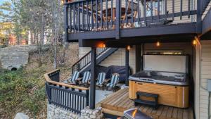 a house with a balcony with a stove on a deck at 5BDR Hot Tub Deck Firepit Mins to Village Lake The Hilltop by AvantStay in North Shore
