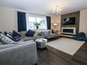 een woonkamer met een bank en een open haard bij The Willows in Trearddur