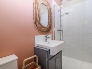 een badkamer met een wastafel en een spiegel bij The Willows in Trearddur +16 foto's