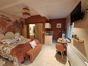 a bedroom with a large bed and a kitchen at La Cour d'Hortense in Sailly-Flibeaucourt