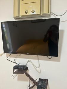 un televisore appeso a una parete con un telecomando di Espaço mel a Búzios