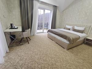 a bedroom with a bed and a desk and a window at Gabala Bless Hotel Cottage in Gabala +76 photos