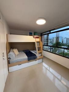 a bedroom with a bunk bed with a large window at Oceanfront Playa Grande 10 min Airport Maiquetia Aeropuerto in Maiquetía