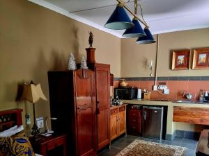a kitchen with blue pendant lights and a large cabinet at Koekeloer Selfcatering Cottages in Nieu-Bethesda