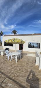 a table and chairs with an umbrella in front of a building at Beach house in Zarzis