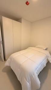 a white bed in a white bedroom with a white cabinet at Refugio de lujo Piscina con Vistas panorámicas in Encarnación