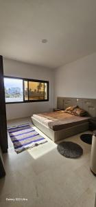 a bedroom with a large bed and a large window at Beach house in Zarzis