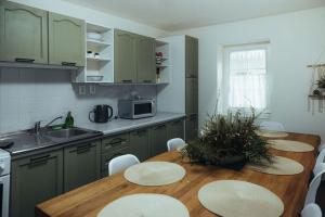 a kitchen with a wooden table with chairs and a sink at Chalupa Laura in Bublava