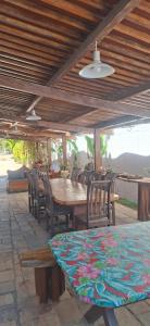 Pousada Recanto do Cajueiro في ساو جوزيه دا كوروا غراندي: طاولة وكراسي خشبية تحت سقف خشبي +58 صورة