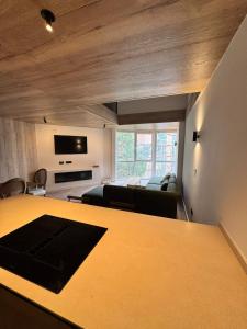 een woonkamer met een tafel, een bank en een tv bij EUROPA Dúplex reformado en verano25 in Sierra Nevada